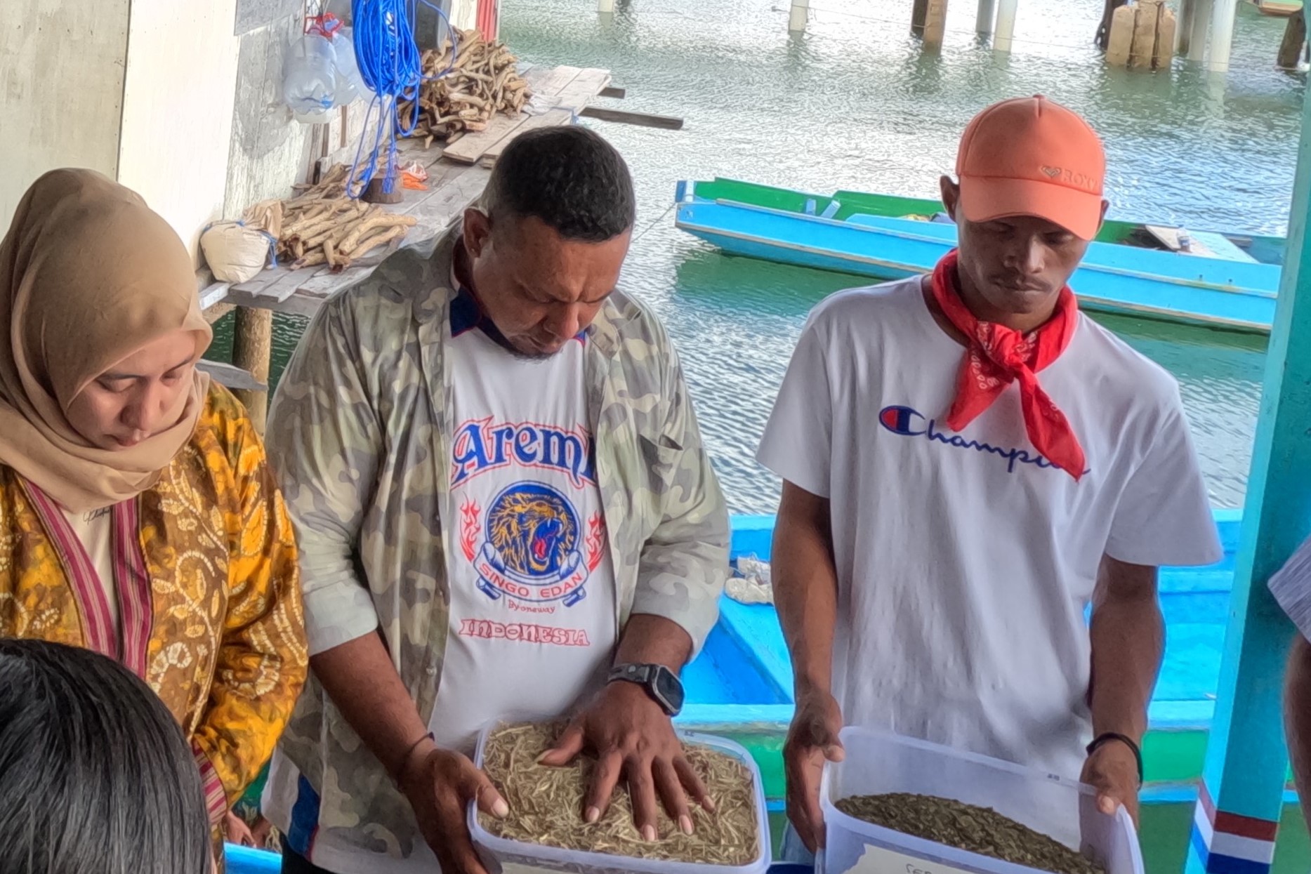 Sesi doa bersama sebelum uji coba, peserta memegang bubuk campuran dengan penuh harap, memohon hasil terbaik bagi budidaya rumput laut Photo: ©WWF-Indonesia/ Annisa S. Aulia