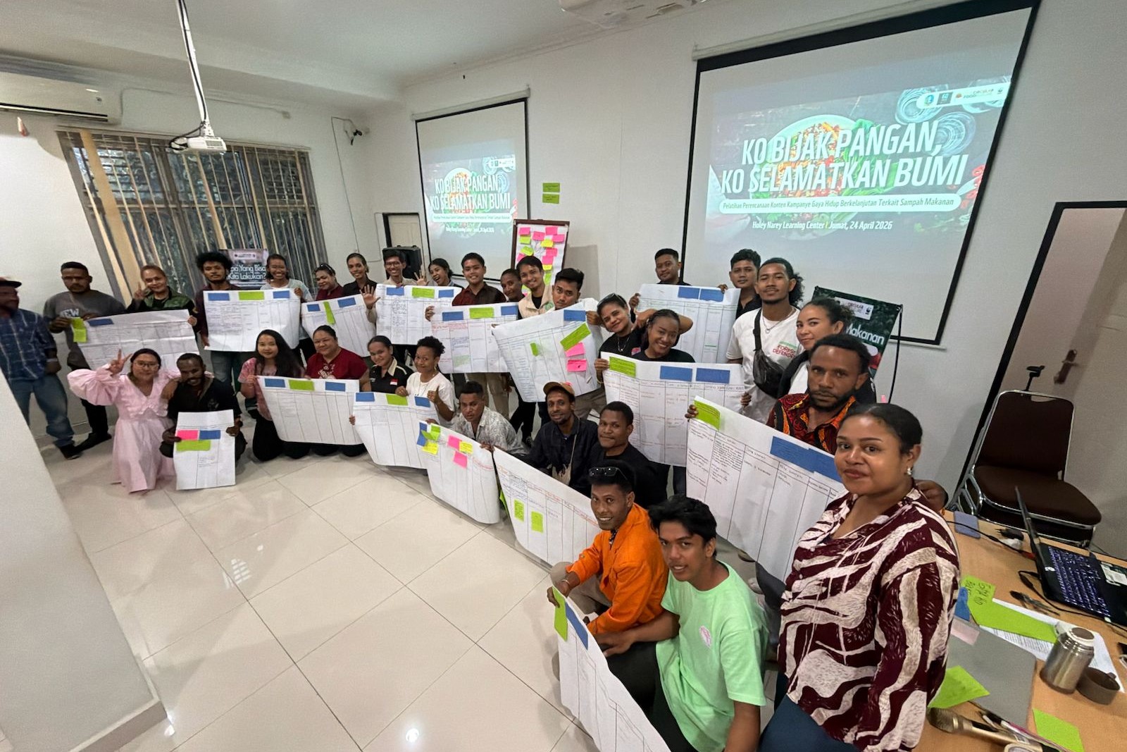 Group photo of environmental community, interfaith youth, indigenous people, and fellow students holding the campaign content planning paper that has been compiled together.